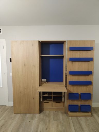 Mueble de madera con puertas abiertas, estantes azules y un escritorio en la parte inferior.
