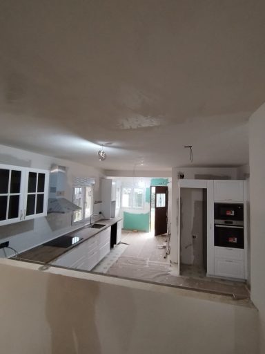 Cocina remodelada con paredes claras y mobiliario moderno en proceso de finalización.