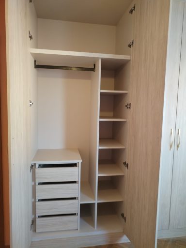 Armario vacío con estantes, cajones y una barra para colgar ropa.