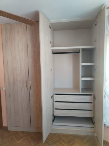 Armario de madera claro con puertas, estantes y cajones abiertos.